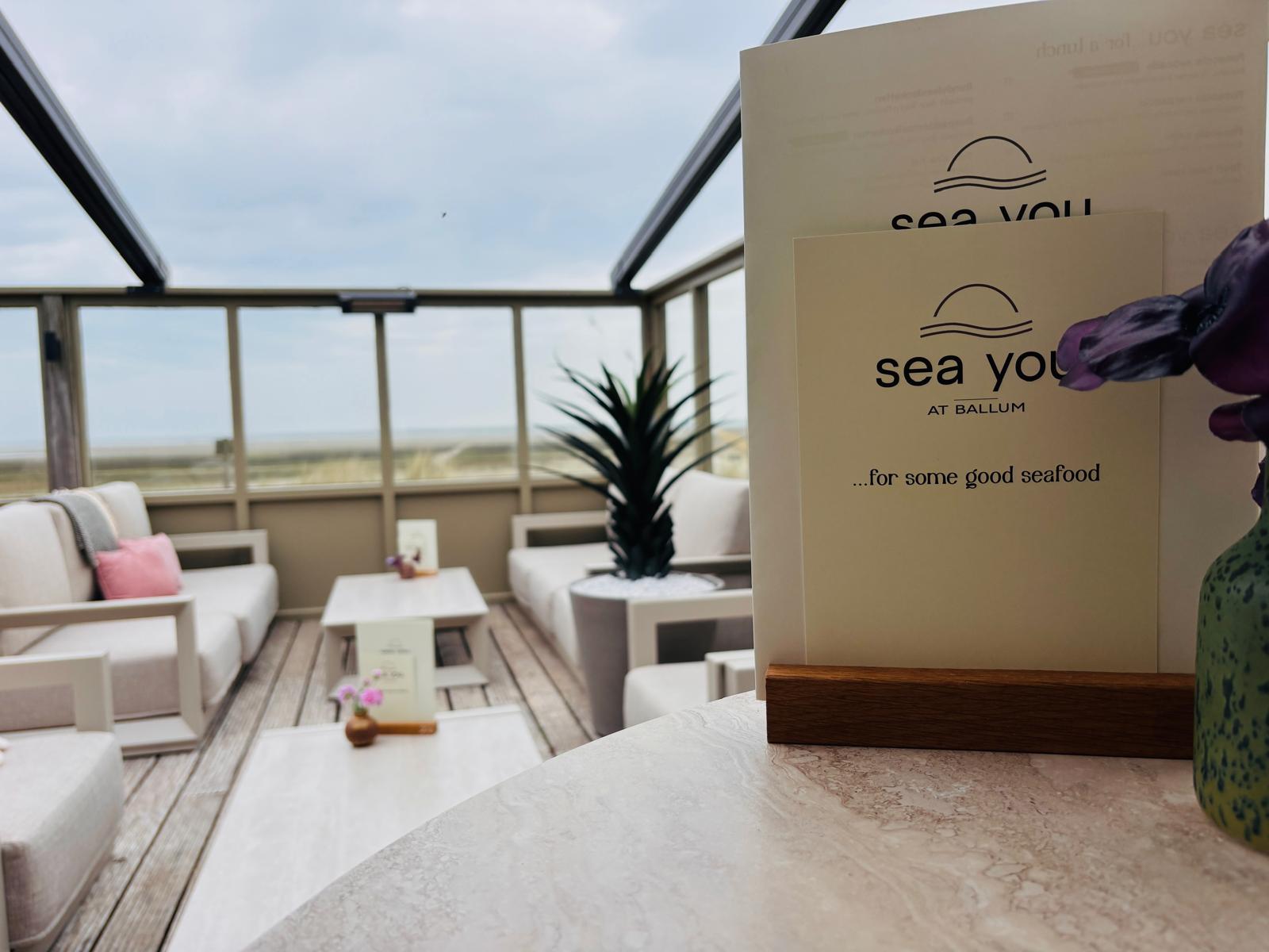 Lounge met zeezicht en menukaart van Sea You at Ballum — de perfecte setting voor een zakelijk overleg