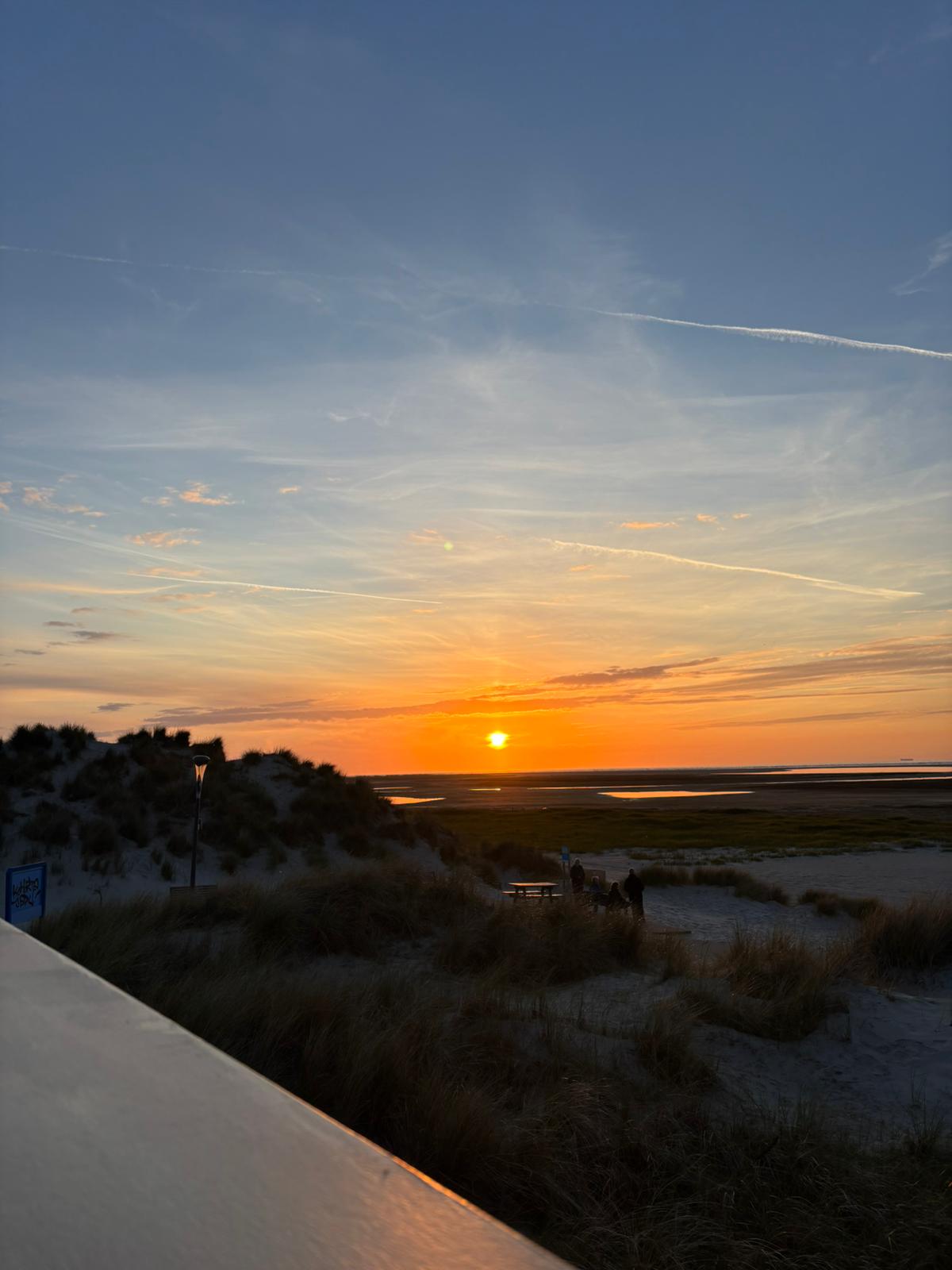 Zonsondergang boven de duinen en het wad van Ameland gezien vanaf Sea You